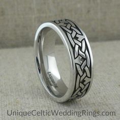 a wedding ring with an intricate design on the outside and inside, sitting on a carpeted surface