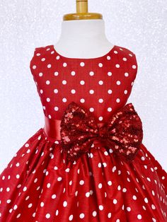 Hand stitched together with the upmost care, this dress is perfect for any occasion: birthdays, pageants, photoshoots, and holiday parties! The comfortably soft polka dot dress is made out of cotton material; The bodice is sleeveless with a zipper in the back. The dress comes with a detachable ribbon sash and mini sequin small bow to add sparkle. Knee length skirt made out of cotton polka dot fabric. Under the skirt is one layer of lining with crinoline attached to add extra puffiness. *Mannequi Red Dresses For Kids, Knee Length Gown, Newborn Flower, Christmas Pageant, Red Polka Dot Dress, Under The Skirt, Dot Fabric, Polka Dot Fabric, Inspired Dress