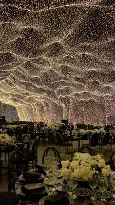 the ceiling is covered with hundreds of lights and tables are set up for an event