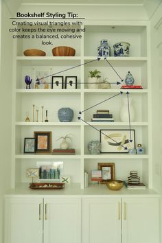 a white bookcase filled with lots of books and vases on top of it