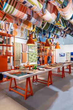 a room filled with lots of different colored lamps and tables covered in colorful cloths