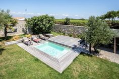 an aerial view of a backyard with a pool and lounge chairs in the foreground