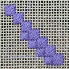 a close up of a piece of cloth with purple thread on it and an arrow in the middle