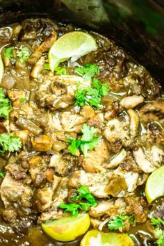 a close up of food in a crock pot with lemons and cilantro