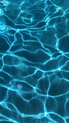 the water is very blue and it looks like ripples in the pool or lake