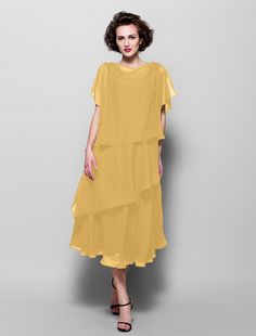 a woman is wearing a yellow dress with tiered ruffles on the bottom