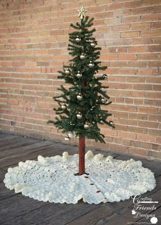 a small christmas tree in front of a brick wall