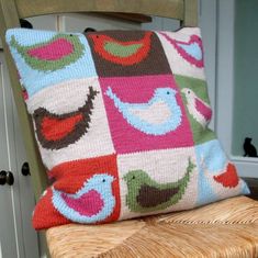 a cushion with birds on it sitting on a chair