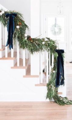 the garland on the banister is decorated with pine cones, berries and greenery