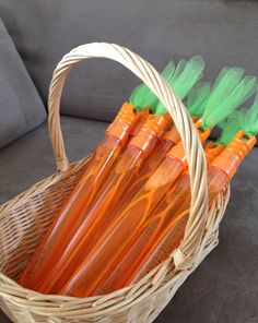 a wicker basket filled with orange and green plastic straws on top of a couch