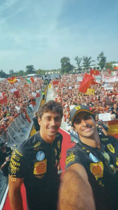 two men standing next to each other in front of a crowd