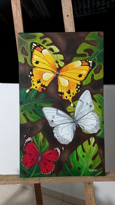 a painting of three butterflies on a green leafy background