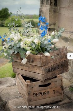 two wooden boxes with flowers in them sitting on the ground