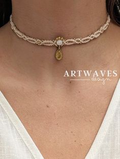 a woman wearing a necklace with a cross pendant on it's neck and the words art waves written below