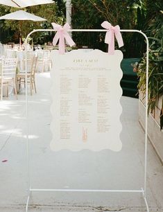 a wedding seating sign with pink bows on it