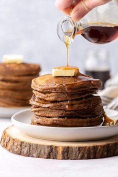 a stack of pancakes with syrup being drizzled on top