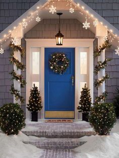 a blue front door decorated with christmas lights and wreaths