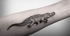 an alligator tattoo on the arm