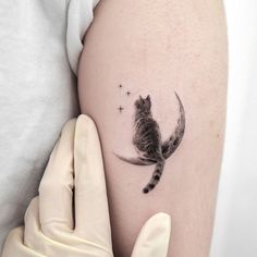 a small cat tattoo on the right side of the thigh, with stars in the background