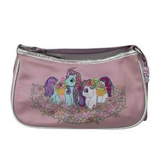 a pink purse with three little ponys on the front and one has flowers around it