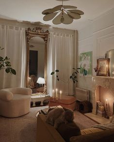 a living room filled with furniture and a fire place in front of a mirror on the wall