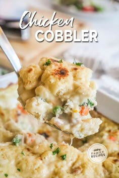 a spoon full of chicken cobbler casserole is being lifted from the casserole dish