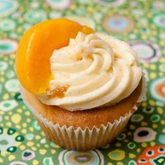 a cupcake with frosting and an orange on top