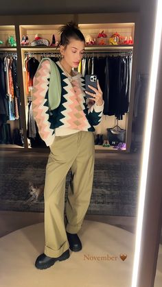 a woman standing in front of a closet holding a cell phone