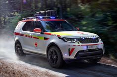 a white suv driving down a dirt road with an emergency light on it's roof