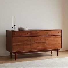 a wooden dresser sitting in front of a white wall