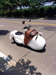 a white and brown motorcycle is parked on the street