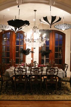 a dining room table with umbrellas hanging from the ceiling