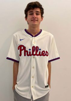 a young baseball player poses for a photo