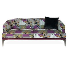 a purple and black couch sitting on top of a white floor next to a pillow