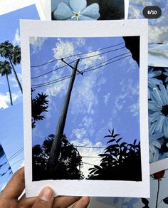 a person holding up some pictures with sky and clouds in the background, while another photo has been placed on top of it