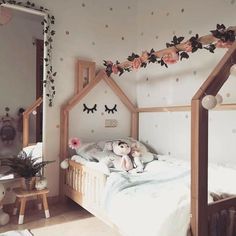 a child's bedroom with white walls and pink flowers on the ceiling, along with a doll house bed