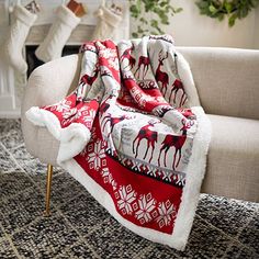 a living room filled with furniture and a fire place covered in a blanket that has reindeers on it