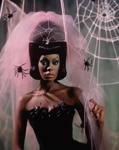 a woman in a black dress with spider webs on her head