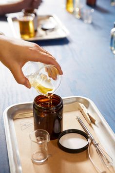 someone is pouring something into a jar on a tray