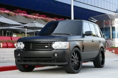 a black range rover is parked in front of a building with steps leading up to it