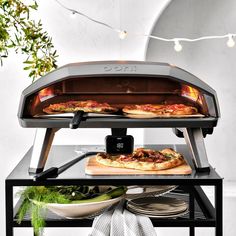 two pizzas are cooking in an outdoor oven