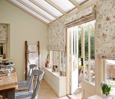 a room that has some chairs in it and windows with blinds on them, along with other furniture