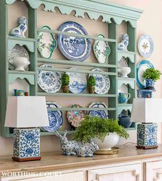 a blue and white china cabinet with plates on it