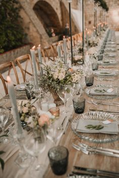 a long table is set with silverware and candles