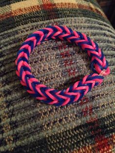 a pink and blue bracelet sitting on top of a couch