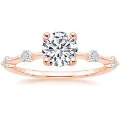 a rose gold engagement ring with two diamonds on the band and a round cut diamond in the center