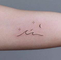 a woman's arm with a small wave tattoo on it