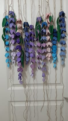 purple and blue flowers are hanging on the wall