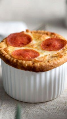 a pepperoni pie in a white dish on a table