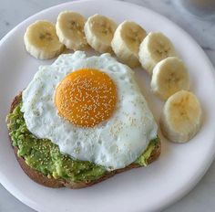 an egg and avocado on toast with sliced bananas